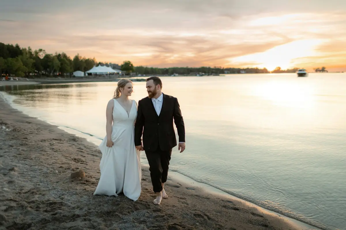 A couple walking along the beach at sunset