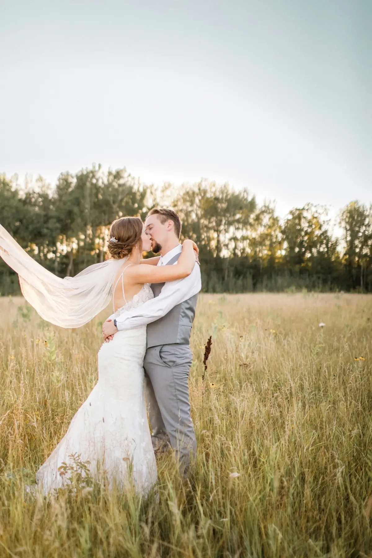 Two people standing close in a sunlit field