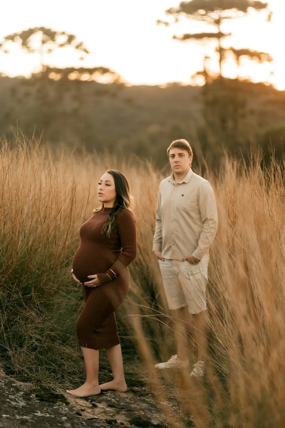 An expecting mother standing in tall grass