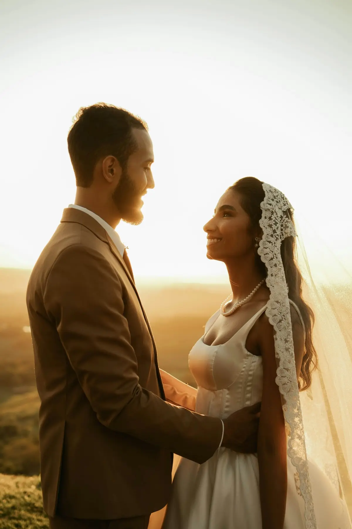 A bride looking through her veil in soft evening light
